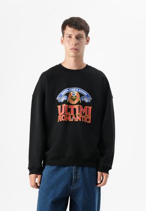 Zwarte sweatshirt met kleurrijke grafische tekst "ULTIMI ROMANTICI" en decoratieve elementen, met een ontspannen pasvorm en geribbelde manchetten.
