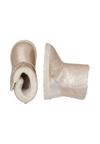 Stivali corti metallici dorati con morbida fodera bianca e suola in gomma bianca flessibile. Presentano una punta arrotondata e una texture liscia e lucida.