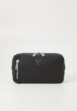 Sac à cosmétiques en cuir noir avec une surface texturée, quincaillerie argentée, doubles zips, et un accent de logo triangulaire sur le devant.