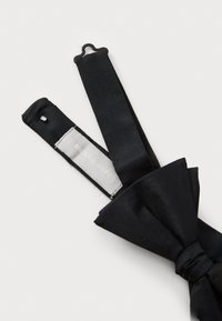 Schwarze Fliege aus glattem Seidenstoff. Verfügt über eine flache Schleife und zwei verstellbare Riemen mit einer metallischen Schlaufe, beschriftet mit "Michael Kors."