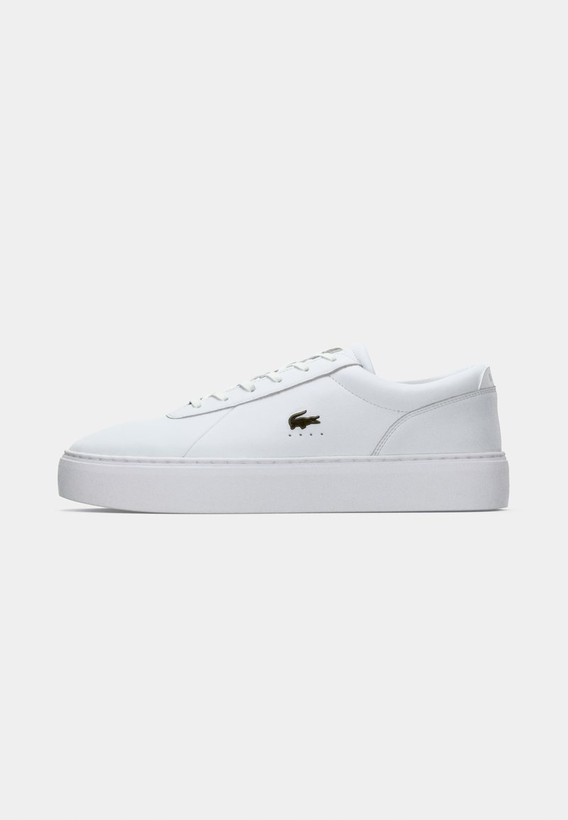 White leather sneaker with a smooth texture, round toe, flat laces, and a rubber sole. Features a small gold logo on the side.