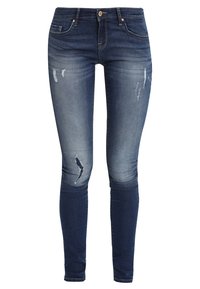 Vaqueros ajustados de mezclilla azul oscura con un ligero desgastado y detalles rasgados. Presenta una cinturilla estándar y un diseño de cinco bolsillos.