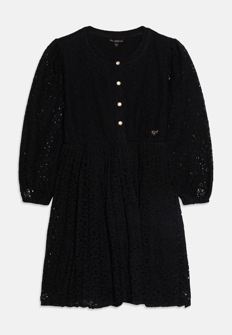 Robe en dentelle noire avec de longues manches bouffantes, encolure ronde, quatre boutons en perle sur le devant et un petit logo métallique en forme de cœur sur la poitrine.