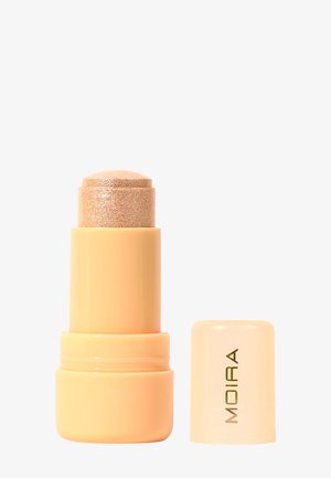 Beige draaibare stick met glinsterende gouden highlighter, naast de bijpassende dop met het opschrift "MOIRA" in gouden letters.