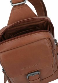 Borsa a tracolla in pelle marrone con diversi scomparti con zip, design elegante e hardware in metallo con dettaglio logo incastonato.