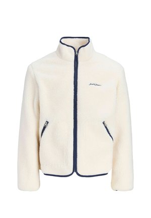 Veste polaire crème avec bordure de fermeture éclair bleu marine, deux poches avant zippées et logo brodé sur la poitrine.