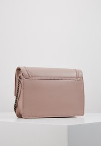 Borsa a mano rettangolare in pelle mauve con bordi cuciti e una catena metallica laterale visibile su una superficie bianca.