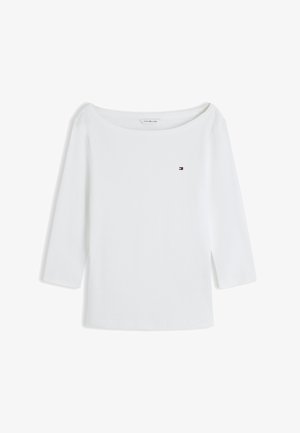 White long-sleeve boat neck shirt with small Tommy Hilfiger logo on left chest, displayed on a white background.