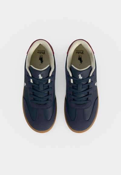 Ζευγάρι σκούρα μπλε αθλητικά παπούτσια Polo Ralph Lauren με λευκό λογότυπο, ταμπά σόλες και μπορντό λεπτομέρειες στη φτέρνα, σε λευκό φόντο.