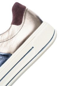 Talons de baskets avec dessus en cuir métallisé, col en suède bordeaux, accent en cuir marine et semelle en caoutchouc blanc avec détail à rayure bleue.