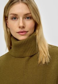 Olijfgroen geribd coltrui met een hoge kraag, gemaakt van textuur gebreid materiaal, met een slim fit ontwerp en subtiele stikdetails.