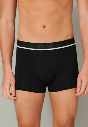 Black cotton boxers with a fitted shape, featuring a black waistband with white accents and the brand name "SCHIESSER" in black lettering.