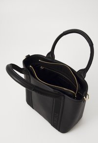 Zwarte leren handtas met dubbele handvatten, ritscompartimenten en hardware in goudkleur. Heeft een gestructureerde afwerking en logo-detail.