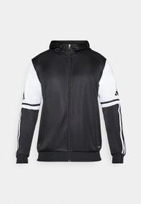 Felpa nera con zip, caratterizzata da maniche bianche e tre strisce bianche lungo le braccia. Realizzata in un tessuto liscio e leggero. Design della felpa incluso.