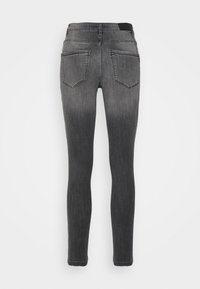 Jeans skinny em denim cinza com um acabamento desbotado, apresentando cinco bolsos, costura visível e uma cintura clássica nas costas.