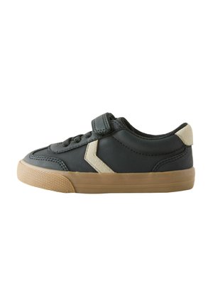 Sort lavtop sneaker med beige Chevron-design, tan gummisål, snørefront og en enkelt velcrolukning på hvid baggrund.