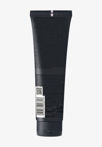 Svart tryckbar tub med lockkräm i matt finish. Har vit text, QR-kod och PETA-logotyp. Volym: 150 ml. Genomskinligt lock på toppen.