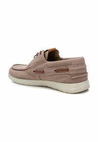 Zapato de barco de lona rosa claro con superficie texturizada, acentos de cuero marrón, diseño con cordones y suela de goma blanca.
