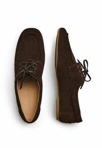 Scarpe in suede marrone con punta arrotondata, design allacciato e cuciture minime. Suole in gomma piatta e interno in pelle liscia.