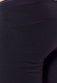 Svarta leggings i elastiskt material, med en slät yta och hög midja med subtila sömdetaljer.