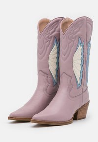 Lawendowe skórzane kowbojki z ostrymi noskami, zdobione niebieskimi i kremowymi wzorami w kształcie skrzydeł, z haftowanymi detalami i niskim drewnianym obcasem.