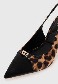 Slingback kiilakorkokengät leopardikuviolla, teräväkärkiset, mustalla kankaalla varustettu kärki ja kultaiset yksityiskohdat. Ominaisuuksiin kuuluu tyylikäs muotoilu ja teksturoitu pinta.