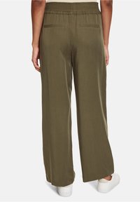 Brede broek in olijfgroene stof met een elastische tailleband, voorzien van twee achterzakken en een gladde textuur.