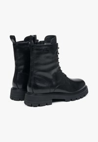 Černé kožené kotníkové boty s šněrováním a kovovými očky, polstrovaným límcem a drsnou gumovou podrážkou pro lepší přilnavost.