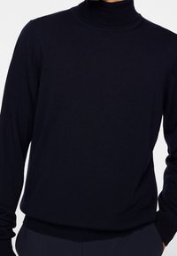 Marinefarbener Rollkragenpullover aus feinem Strickstoff mit tailliertem Design, langen Ärmeln und gerippten Akzenten am Kragen und Saum.