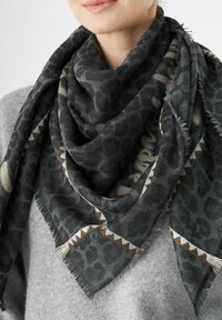 Sciarpa con stampa leopardata nera e grigia con bordi frangiati, caratterizzata da una trama testurizzata e accenti geometrici a contrasto in beige e marrone.