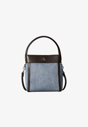 Kleine Handtasche mit hellblauem Stoffkörper und dunkelbraunen Lederbesätzen und Griffen, mit einem kleinen metallischen "cK" Logo auf der Vorderseite.