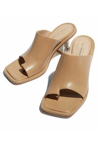 Tan open-toe mules met een vierkant teenbox, een gladleren bovenwerk en een lage, transparante hak. Minimalistisch ontwerp zonder versieringen.