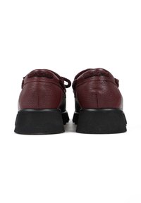 Bordowe skórzane buty z teksturowanym wykończeniem, z czarnymi gumowymi podeszwami i sznurówkami, zaprojektowane z myślą o komforcie i wsparciu.