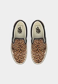 Paire de chaussures Vans sans lacets à motif léopard avec bordure noire, vue de dessus sur fond blanc.