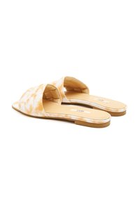 Slide sandalen met een gladde bovenkant van gele en witte tie-dye stof, open teenontwerp, platte zool en minimale hardwaredetails.