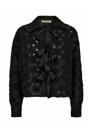 Črna bluza z dolgimi rokavi, ki ima teksturiran cvetlični dizajn, prosojno tkanino in tri satenaste pentlje spredaj.