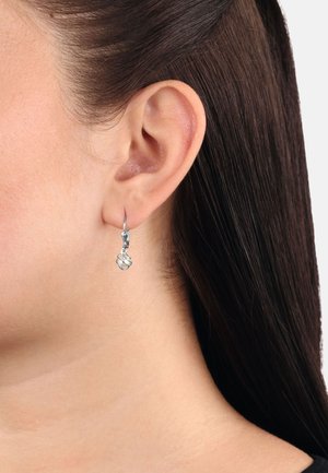 Los pendientes de gota de plata presentan un diseño retorcido con un delicado eslabón de cadena y un acabado pulido, colgando de un aro simple.
