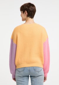 Maglione a costine con corpo giallo e maniche viola e rosa. Il design presenta una vestibilità comoda e un collo rotondo.