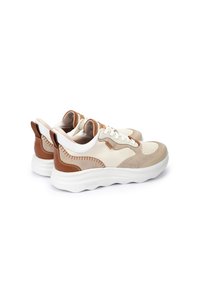Une paire de baskets basses beige et marron avec de solides semelles blanches, un système de laçage et des panneaux en cuir et en daim cousus.