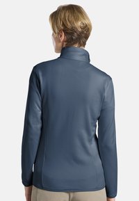 Pull-over à manches longues, bleu foncé, avec une surface texturée et un col haut, conçu pour le confort et la liberté de mouvement.