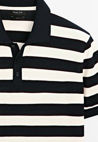 Black and white horizontal striped polo shirt with a collar and three buttons, short sleeves, Massimo Dutti label visible inside collar.