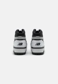 Sneaker alte nere e grigie con upper in pelle liscia, colletto imbottito, suola in gomma e logo 'N' sul tallone.