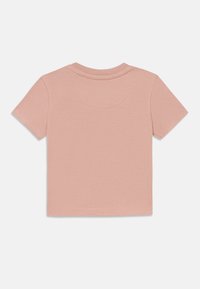 T-skjorte med korte ermer i rosa, laget av myk stoff. Har rund hals og flate sømmer, med en jevn tekstur og enkelt design.