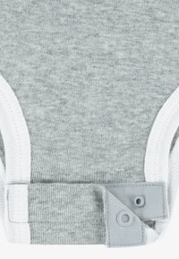 Body din bumbac gri, cu tiv alb, prevăzut cu capse în partea de jos pentru o îmbrăcare ușoară. Material moale, texturat, cu aspect melanj.