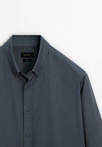 Camicia button-up di colore grigio scuro, realizzata in cotone. Presenta un colletto classico, una pattina frontale con bottoni e maniche corte. Tessuto semplice.