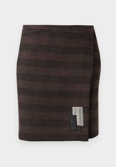 Barna szoknya struktúrált anyagból, amelyen vízszintes csíkok különböző árnyalataiban láthatók. Az oldalon található címke a márkanevet és a kezelési utasításokat tartalmazza.