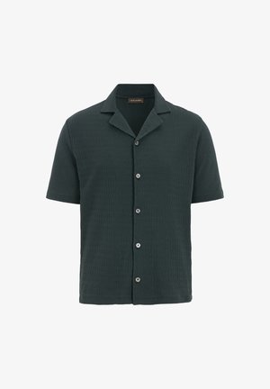 Koszula z krótkim rękawem w ciemnozielonym teksturowanym materiale, z kołnierzykiem w kształcie litery V i zapinana na czarne guziki.