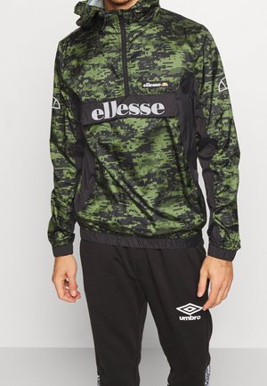 Veste coupe-vent camouflage en vert et noir, dotée d'un design à demi-zip, de poignets élastiques et d'un logo imprimé sur la poitrine et la poche.