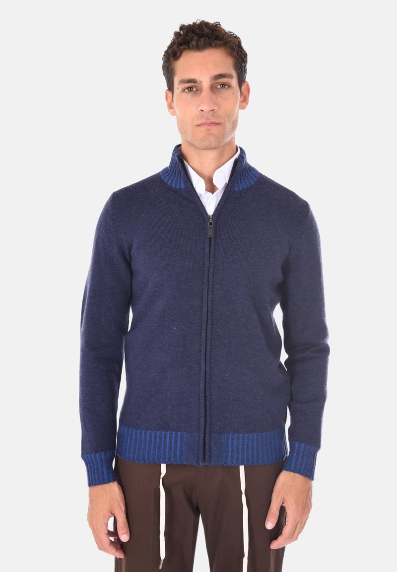 Maglione navy con zip in morbido tessuto, caratterizzato da un colletto e polsini a costine di un blu più chiaro, con costine verticali all'orlo.