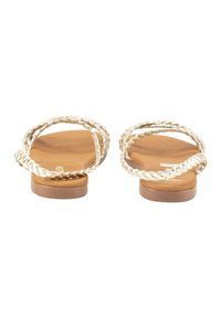 Sandalias trenzadas con dos correas trenzadas, suelas marrones y un diseño plano. Presentan una textura suave y una parte trasera minimalista. Sin adornos.